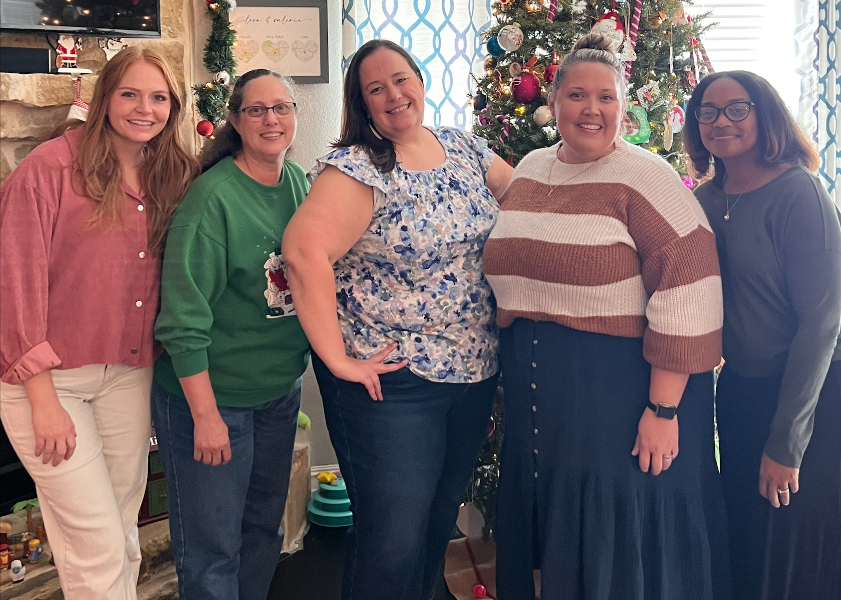 Board certified teachers pose in front of a christmas tree